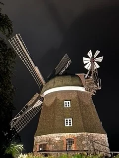 Windmühle unter dramatischem Nachthimmel