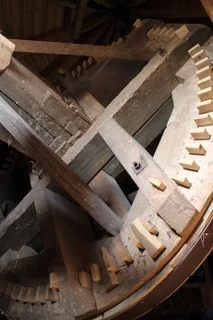 Nahaufnahme des hölzernen Zahnradgetriebes im Mühleninneren