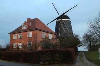 Backsteingebäude mit Windmühle auf dem Mühlengelände